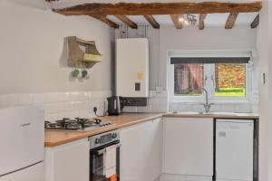 a kitchen with white cabinets and a sink at Malvern House in Banbury +2 photos