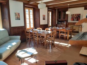 a dining room with a table and chairs and a couch at Auberge des Volcans in Saint-Chamant
