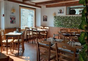a restaurant with wooden tables and chairs in a room at Auberge des Volcans in Saint-Chamant