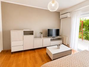 a living room with a white cabinet and a tv at APARTMENTs MARIJA SENJ in Senj
