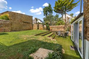 a garden with a table and chairs next to a brick wall at Malvern House in Banbury