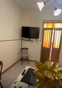 a living room with a flat screen tv and a chair at B&B da Alessandro in Palmi