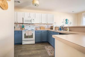 a kitchen with blue cabinets and white appliances at CoastalBoho-Spacious 4BDtownhouse 3 mi from beach in Rehoboth Beach
