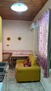 a kitchen with a yellow couch and a table at B&B da Alessandro in Palmi