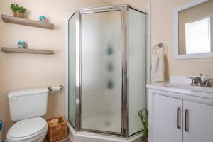 a bathroom with a shower and a toilet and a sink at CoastalBoho-Spacious 4BDtownhouse 3 mi from beach in Rehoboth Beach +51 photos