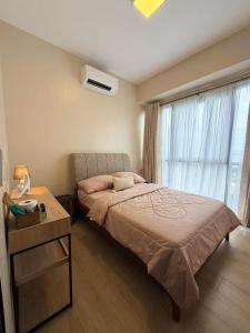 a bedroom with a bed and a table and a window at McBride Suites in Punta Engaño
