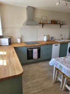 a kitchen with blue cabinets and a stove top oven at Brent Top in Penrith +10 photos
