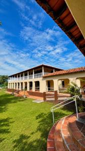 a school building with a green lawn in front of it at Hotel Harmonia Sarapuí in Sarapuí