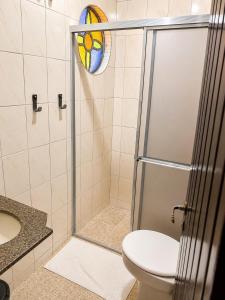 a bathroom with a shower with a toilet and a sink at Hotel Harmonia Sarapuí in Sarapuí