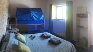 a bedroom with a bed with a blue blanket at Nuit pour 4 en Auvergne in Vallon-en-Sully