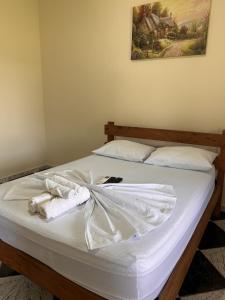 a bed with white sheets and towels on it at Hotel Harmonia Sarapuí in Sarapuí +4 photos