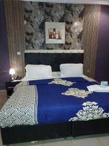 a bedroom with a bed with a blue and white blanket at Pulville Boulevard Hotel in Suru Lere +20 photos