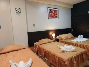 a hotel room with two beds with towels on them at Hotel Dubái in Tacna +8 photos