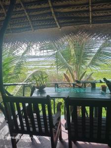 a table and chairs with palm trees in the background at Lake Face Cabana in Tissamaharama
