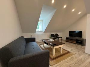 a living room with a couch and a table at Apartmány Tonny in Jáchymov