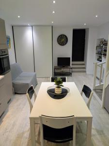 a kitchen and living room with a table and chairs at Charmant Cocon, terrasse proche Clermont in Tallende +2 photos