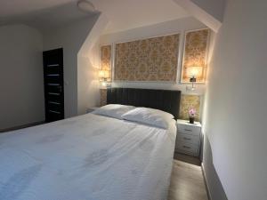 a bedroom with a large white bed with two pillows at Apartmány Tonny in Jáchymov