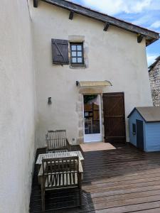 a patio with two benches on a wooden deck at Charmant Cocon, terrasse proche Clermont in Tallende