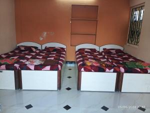 two beds sitting next to each other in a room at Parshotam Home Stay in Dwarka