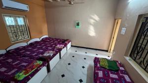 a room with two beds and a window at Parshotam Home Stay in Dwarka
