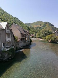 a river with houses and buildings next to a mountain at Chez Christine in Sarrancolin