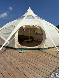 a white tent sitting on a wooden deck at Glamping, Tåsinge - Svendborg in Svendborg