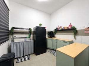 a kitchen with a black refrigerator and a counter at Seabreeze Hideout at Pantai Klebang Netflix I Wifi I Massage Chair I 7 pax in Malacca