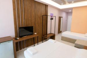 a room with two beds and a television in it at AMMEN Rooms in Shëngjin +28 photos