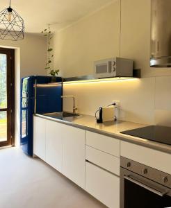 a kitchen with white cabinets and a sink at Casa Olivi, Fermo in Fermo