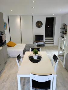 a living room with a table and a bed at Charmant Cocon, terrasse proche Clermont in Tallende
