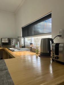 a kitchen with a counter top with a coffee maker and a microwave at Ingloo in Puerto Natales