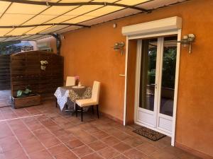 a patio with a table and a glass door at Le Relais des Templiers in Villecroze