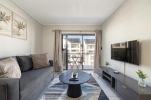 a living room with a couch and a table at #AlimamaSpaces The Contemporary Retreat in Midrand