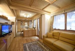 a living room with a couch and a television at Romantic Chalet Dolomiti in Val di Zoldo