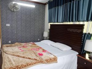 a bedroom with a bed with a white bedspread at BHURBAN view APARTMENTS in Murree +6 photos