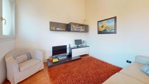 a living room with a couch and a tv at Borgo del Torchio C8 ByBookinggardalake in Manerba del Garda