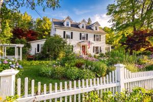 a white picket fence in front of a white house at Launchpoint Lodge in Lincoln