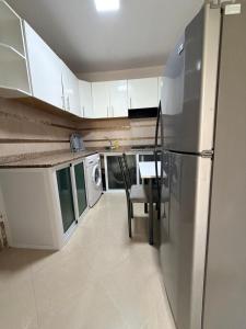 a kitchen with a stainless steel refrigerator and a table at casa jihan playa TGV in Tangier