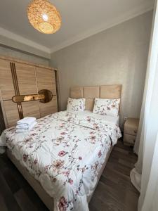 a bedroom with a bed with a floral bedspread at casa jihan playa TGV in Tangier