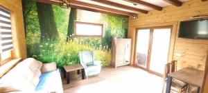 a living room with a couch and a tv on a wall at Bacówka pod Ślężą in Sulistrowice