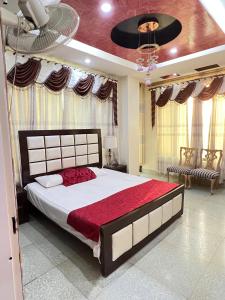 a bedroom with a large bed with a red blanket at BHURBAN view APARTMENTS in Murree