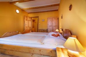 a bedroom with a large bed with white sheets at Penzión - Restaurant Atrium in Poprad