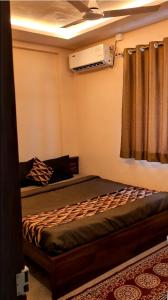 a bedroom with a bed in a room with a window at Hotel Sai Vandan in Nagpur