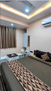 a room with a bed and a table and a couch at Hotel Sai Vandan in Nagpur