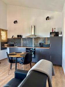 a kitchen with blue cabinets and a table and chairs at MARANGUN Drage apartman in Drage