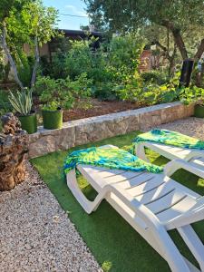 a white bench sitting on the grass in a garden at MARANGUN Drage apartman in Drage