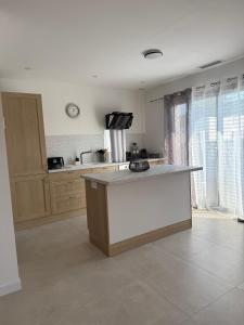 a kitchen with a white island in a room at Porte de la Méditerranée in Perpignan