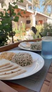a table with plates of food and a glass of water at Boli Dhigurah in Dhigurah