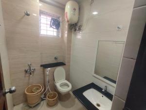 a bathroom with a toilet and a sink at Raya Raj Anugraha in Kumbakonam