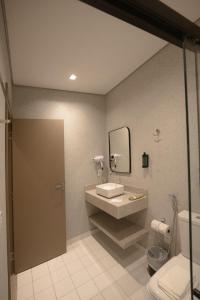 a bathroom with a sink and a mirror and a toilet at Village Rio Hotel in Chavantina